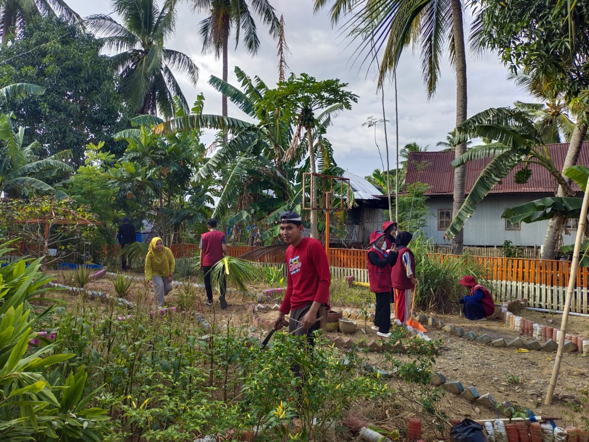 Pemdes Mario Bersama Mahasiswa KKN UNIPRIMA Lakukan Pemangkasan Ranting di Ruas Jalan Desa